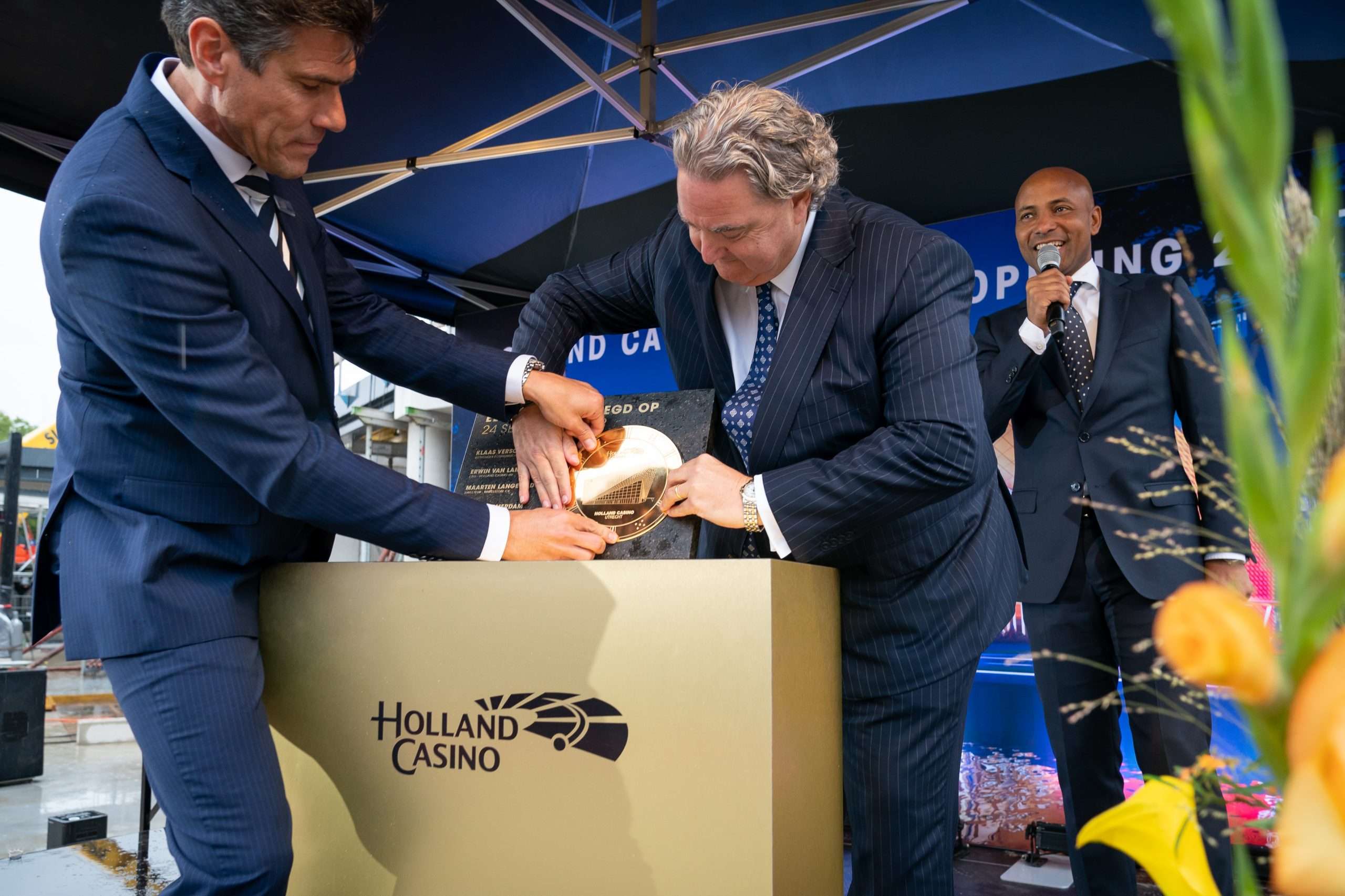 Jerry Warmerdam (casinomanager Holland Casino Utrecht) en Erwin van Lambaart (CEO Holland Casino) leggen de eerste steen. Op de achtergrond presentator Humberto Tan.