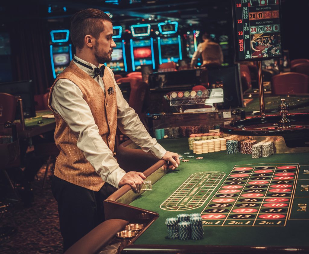 Croupier (dealer) achter een roulettetafel (bron: Envato)