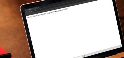 Mock-up van een laptop met een melding op de website freebitco.in van een blokkade van de Kansspelautoriteit.